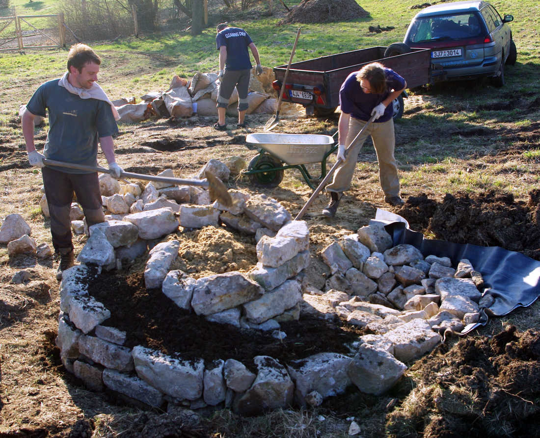 Doplňování zeminy mezi hotovou zídku spirály Zemina mezi kameny
